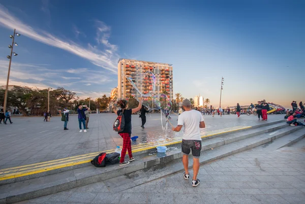 BARCELONA, SPAGNA - 10 NOVEMBRE 2015: Uomini e donne non identificati soffiano grandi bolle di sapone su Placa del Mar la sera per i turisti il 10 novembre 2015 a Barcellona, Spagna — Foto Stock