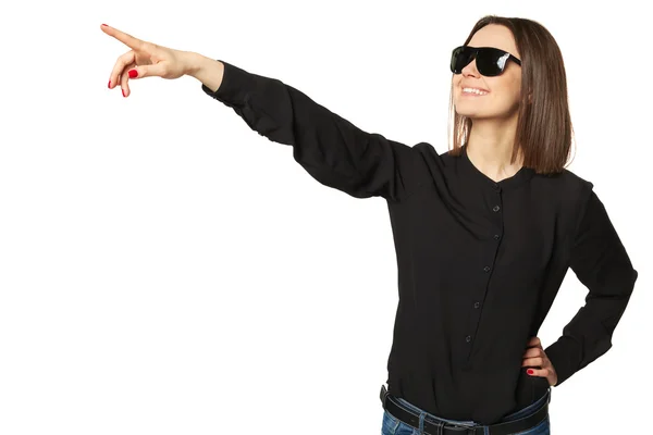 Attractive woman in black shirt and sunglasses pointing towards copy space area. — Stock Photo, Image