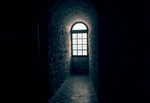 Solljus lyser genom ett fönster i ett gammalt slott Stockbild