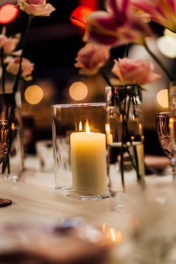 Sofra takımı, şarap bardakları ve yumuşak doğal ışıkla aydınlatılmış beyaz peçetelerle süslenmiş zarif bir masa. İç dizayn, etkinlik veya konukseverlik kavramları için mükemmel..