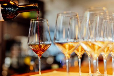 Sıcak bir restoran atmosferinde şarap kadehleri ve sıcak altın bokeh ışıkları olan zarif bir Noel sofrası..