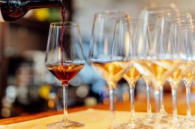 Sıcak bir restoran atmosferinde şarap kadehleri ve sıcak altın bokeh ışıkları olan zarif bir Noel sofrası..