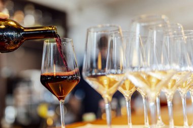 Sıcak bir restoran atmosferinde şarap kadehleri ve sıcak altın bokeh ışıkları olan zarif bir Noel sofrası..