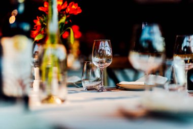 Sıcak bir restoran atmosferinde şarap kadehleri ve sıcak altın bokeh ışıkları olan zarif bir Noel sofrası..