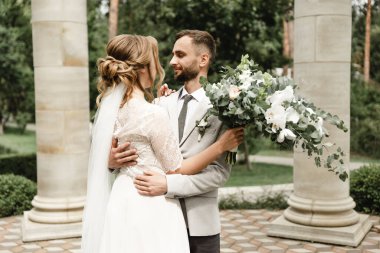 Düğün günü damada dokunmak, parkta bir çift buluşması, neşeli bir çift, sakallı gülen damat neşeli bir geline bakar.