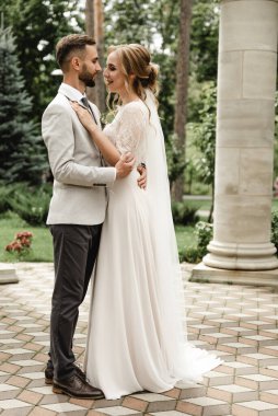 Düğün günü damada dokunmak, parkta bir çift buluşması, neşeli bir çift, sakallı gülen damat neşeli bir geline bakar.