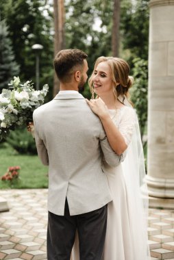 Düğün günü damada dokunmak, parkta bir çift buluşması, neşeli bir çift, sakallı gülen damat neşeli bir geline bakar.