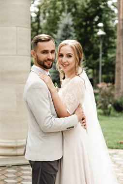 Gelin ve damat düğün günlerinde, bahar doğasında dışarıda yürüyorlar. Yeni evli, mutlu yeni evli bir kadın ve yeşil bir parkta kucaklaşan bir adam. Dışarıda sevgi dolu bir çift..