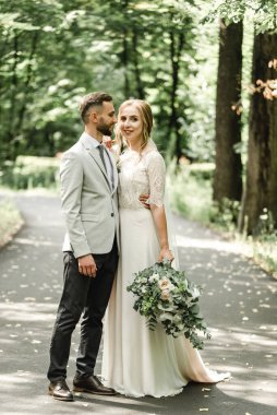 Parktaki düğün çifti, parkta öpüşen Avrupalı gelin ve damat, düğün günlerinde parkta mutlu gelin ve damat.