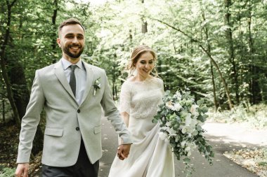 Açık havada dans eden evli bir çift, boş alan. Gelin ve damat kucaklaşması, bulanık yeşil çimen arka planı. Düğün dansının ilk konsepti