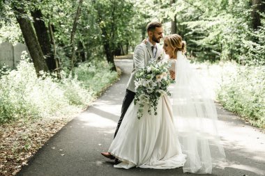 Açık havada dans eden evli bir çift, boş alan. Gelin ve damat kucaklaşması, bulanık yeşil çimen arka planı. Düğün dansının ilk konsepti