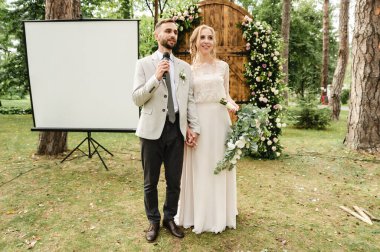 Yeni evliler şükranlarını mikrofona yansıtıyorlar. Yeni evliler mikrofonla şarkı söylüyorlar.