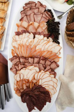 Etli meze, düğün masasında büyük bir tepsi doğranmış et, et kesme tahtası, büfe masası, çeşitli organik etler.