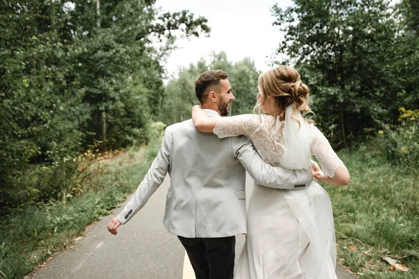 Evlilik gününde çılgın mutlu çift, düğün gününde iki kişilik yürüyüş, damadı bozkırda çılgın gelin, damat gelininin elini tutuyor.