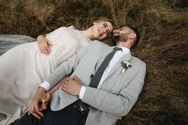 Ευτυχισμένο Ζευγάρι Του Γάμου Είναι Ξαπλωμένος Στο Γρασίδι Και Γελώντας — Φωτογραφία Αρχείου