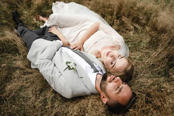 Щаслива Весільна Пара Лежить Траві Багато Сміється Наречений Наречена Разом — стокове фото