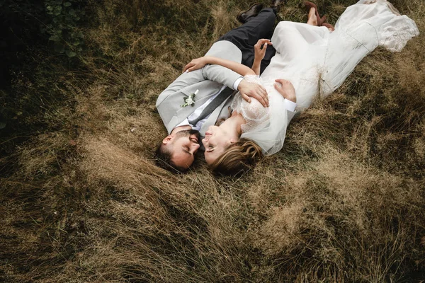 Красивая Сказочная Счастливая Невеста Стильный Жених Лежат Траве Наслаждаться Объятиями — стоковое фото