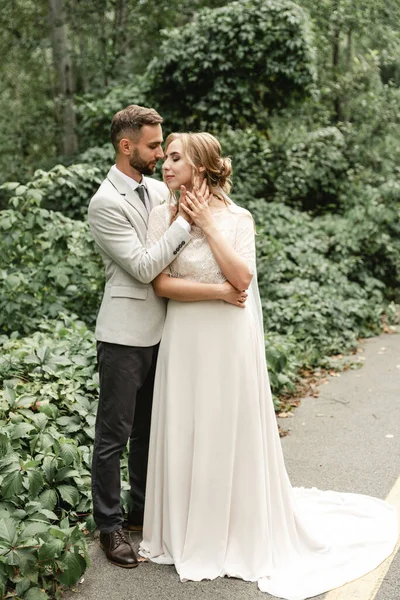 Recém Casados Férias Abraços Ternos Jovem Casal Noivo Toca Rosto — Fotografia de Stock