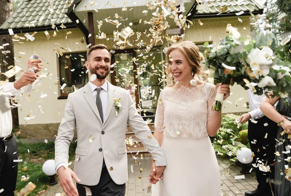 Düğün konfetisi, yeni evliler şenlikli konfetilerle karşılanır, neşeli gelin ve damat yağmurda konfetiyle bir düğün gününe giderler.