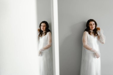 Düğün günü sabah hazırlıkları sırasında genç ve güzel bir gelinin portresi. Güzel kız kafasında bir peçe tutuyor. Gelinin düğün sabahı.