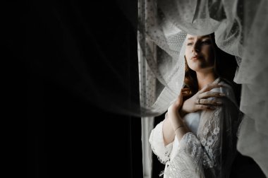 Düğün günü sabah hazırlıkları sırasında genç ve güzel bir gelinin portresi. Güzel kız kafasında bir peçe tutuyor. Gelinin düğün sabahı.