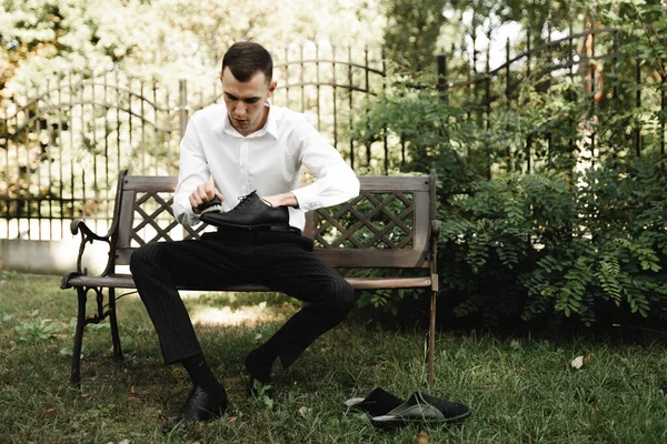 a man cleans leather men's shoes with a brush and a rag. black shoes with a tassel. leather shoes on the table with polishing equipment. shoe shine, fashion, handicraft.