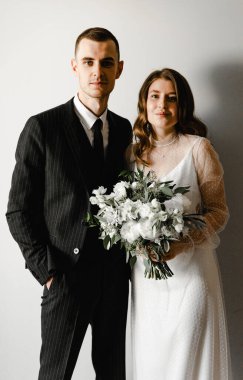 Muhteşem bir düğün çifti portresi. Gelin ve damat kucaklaşırken evdeyken kameraya bakın. Yeni evliler evdeler..