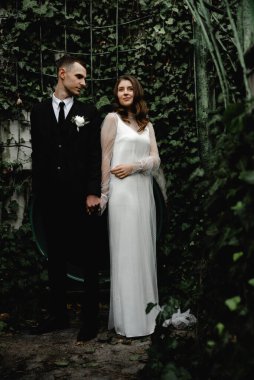 Düğün günü damada dokunmak, parkta bir çift buluşması, neşeli bir çift, sakallı gülen damat neşeli bir geline bakar.