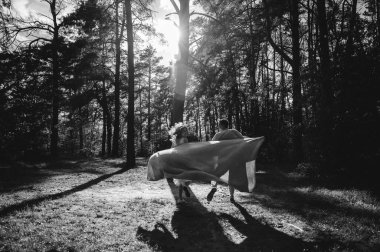 Birbirine aşık güzel bir çift parkta eğleniyor. Genç insanlar ellerinde ekoseyle koşuyorlar. Ormanda romantik bir randevu. bahar yürüyüşü.