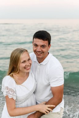 Yazlık elbiseli bir kızla bir adam okyanusun kenarında yürüyor. Karı koca, deniz kenarında romantik bir gün batımında. Aşıklar kumsalda koşar. Yeni evliler için balayı.