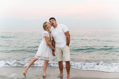 Yazlık elbiseli bir kızla bir adam okyanusun kenarında yürüyor. Karı koca, deniz kenarında romantik bir gün batımında. Aşıklar kumsalda koşar. Yeni evliler için balayı.