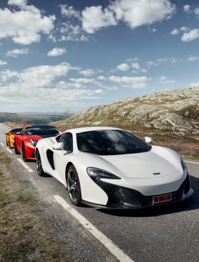 Rjukan, Norveç -04.06.2016: Beyaz Mclaren 650 'ler, Kırmızı Ferrari f12 ve Sarı Lamborghini Huracan. Norveç dağlarında boş bir vadide üç süper araba bir süre durdu..