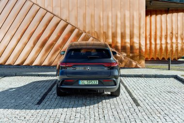 Zory / Polonya-10.06.2020: Elektrikli Mercedes EQC, Ateş Müzesi 'nin altın duvarına karşı duruyor. Arabanın 408HP motoru var ve 5.1 saniyede 0-100 km / saat hızlanıyor. Menzil (WLTP) 369-414 km