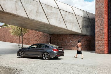 Gri BMW 430i, 252 HP, Avrupa 'nın en modern konser salonlarından biri olan NOSPR binasının önünde duruyor. Katowice, Polonya-06.30.2017