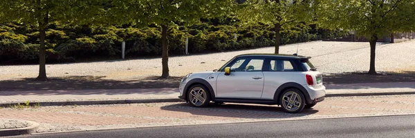 第一个完全通电的迷你车停在树下的街上 Mini发动机的转速范围高达230公里 184匹马力 3秒内从0加速至100公里 波兰卡托维茨 2020 — 图库照片
