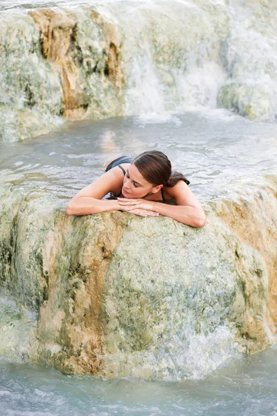 Giovane donna sdraiata nella piscina naturale, Saturnia, Italia — Foto Stock