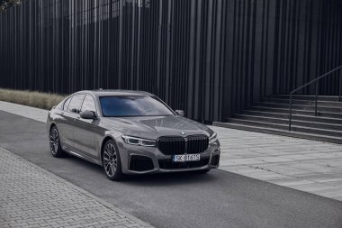 BMW 740D. Lüks bir sedan şık bir şehir caddesinde park halinde. Sahnede modern mimari, temiz hatlar ve açık gökyüzü altında davetkar bir atmosfer yer alıyor. Katowice, Polonya, 13.06.2021