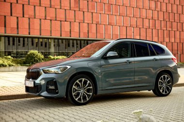 BMW X125, hibrit, fişe takılı araba, modern bir ofis binasının yanına park edilmiş. İki motorun toplam gücü 220HP. Elektrik aralığı 52 km Katowice, Poland- 07.30.2021