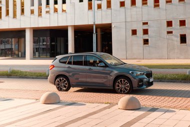 BMW X125, hibrit, fişe takılı araba, modern bir binanın yanına park edilmiş. İki motorun toplam gücü 220HP. Elektrik aralığı 52 km Katowice / Poland- 07.30.2021