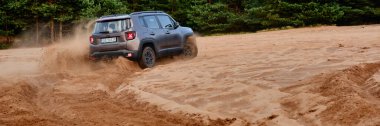 Jeep Renegade çamurlu kumda sürüyor. Çölde 4 'e 4 arabasıyla eğlenmek. Siedlecka Çölü, Polonya 7 Şubat 2017