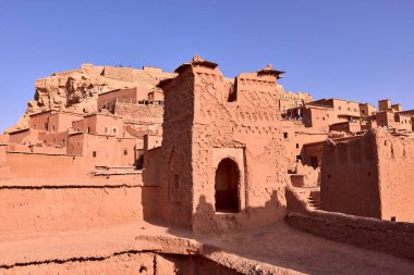 Ait Ben Haddou 'da toprak malzemelerinden yapılmış yapılar bulutsuz bir gökyüzünün altında duruyor. Antik mimari ve çöl manzarası Fas 'ta görülür..