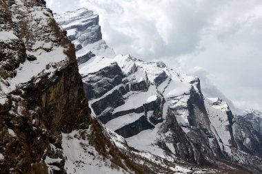 Karla kaplı Rocky dağları Annapurna Ana Kampı 'na giderken gökyüzüne doğru uzanıyor. Bu engebeli Nepal manzarası Himalayaların acımasız güzelliğini gözler önüne seriyor..