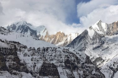 Karlı dağlar çerçeveyi doldurarak Himalayalar 'ın görkemli manzarasını gözler önüne seriyor. Bu, Nepal 'deki Annapurna Sığınağı' nın içindeki gündüz manzarasıdır..