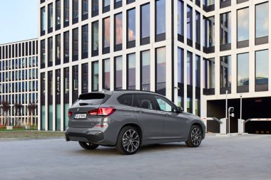 BMW X125e, hibrit, modern ofis binalarının önüne araba tak. İki motorun toplam gücü 220HP. Elektrik menzili 52 km 'ye kadar. Katowice, Poland- 07.30.2021