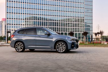 BMW X125e, hibrit, modern ofis binalarının önüne araba tak. İki motorun toplam gücü 220HP. Elektrik menzili 52 km 'ye kadar. Katowice, Poland- 07.30.2021