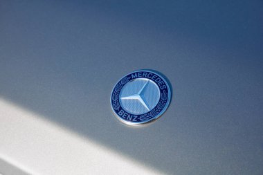 Yakın çekimde, Mercedes-Benz G-sınıfı bir arabanın gümüş amblemi gündüz vakti aracın kaputunda belirgin bir şekilde sergileniyor. Katowice, Polonya, 24.10.2015