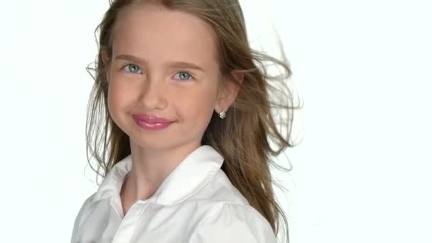 Дівчина-підліток блондинка посміхається і позує на білому тлі, повільний рух — стокове відео