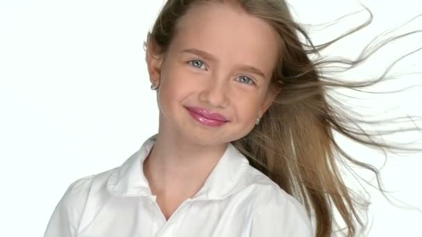 Девушка-подросток блондинка улыбается и позирует на белом фоне, замедленная съемка — стоковое видео