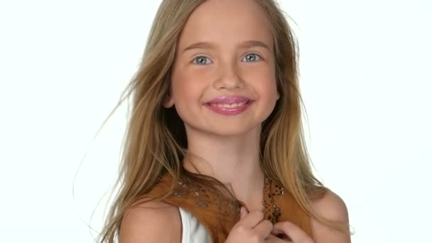 Adolescente chica rubia sonriendo y posando sobre fondo blanco, cámara lenta — Vídeo de stock