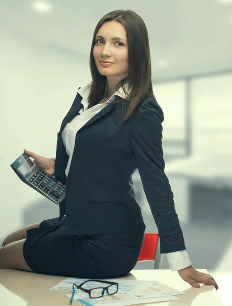 Sekretärin mit Taschenrechner im Amt — Stockfoto